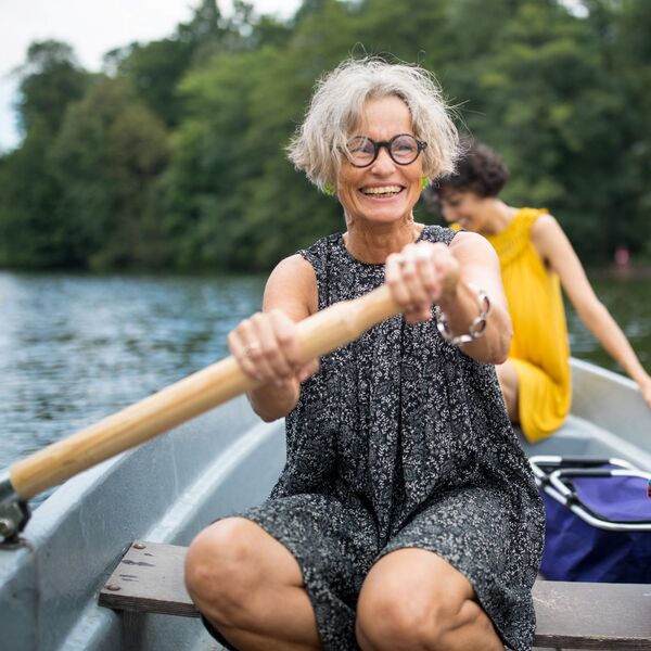 Eine reife Frau rudert auf einem Boot.