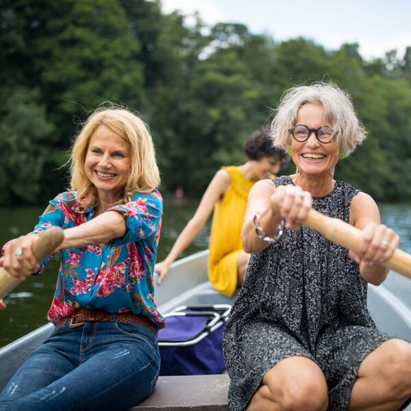 Zwei reife Frauen rudern auf einem Boot.